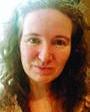 Woman with curly brown hair looking at the camera