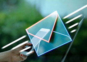 A glowing neon envelope with a smartphone inside, held by a hand against a blurred outdoor background, symbolizing digital communication.