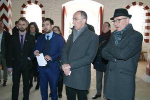 A group of people in suits and winter wear, in what appears to be a religious building 