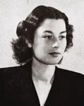 Black and white image of a woman with short hair, looking to the right of the camera. She is wearing a black blazer 