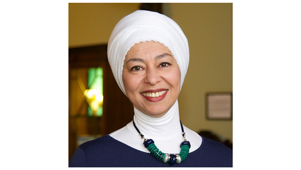 Asian lady wearing a hijab and necklace, smiling at the camera 