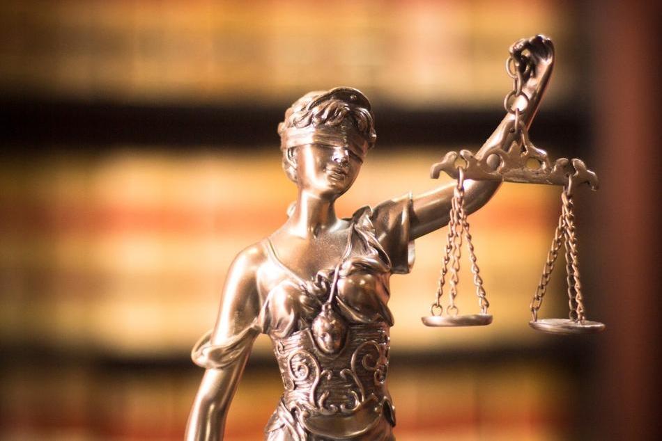 A bronze statue of Justice, blindfolded and holding aloft scales