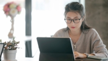 Aisan woman in glasses working on a computer