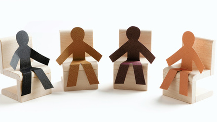 Four stylized people characters, each of a different skin tone, sat in a semicircle 