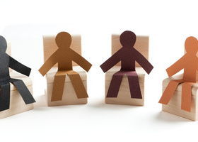 Four stylized people characters, each of a different skin tone, sat in a semicircle 