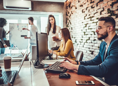 A modern office environment with several people working