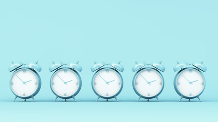 Line of alarm clocks on blue background