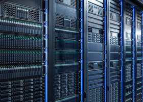 Row of black server racks with blue LED lights in a modern data centre, filled with storage drives and network hardware.